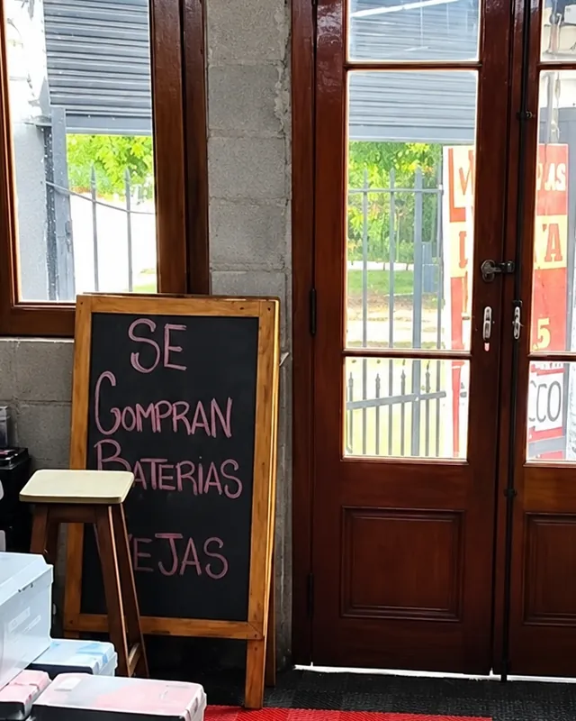Pizarra «Se compran baterías» en la entrada del local
